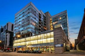 Chicago apartment for rent - A modern building with a glass facade and a sign that reads