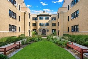 Chicago apartment for rent - a courtyard between two buildings with benches and grass