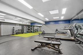Chicago apartment for rent - A gym with a bench, weights, and exercise equipment.