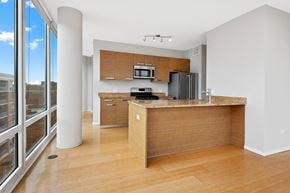 Chicago apartment for rent - a kitchen with wooden cabinets and a large window