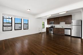 Chicago apartment for rent - an empty kitchen and living room with wood flooring and stainless steel appliances
