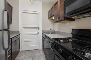 Chicago apartment for rent - a kitchen with a stove and sink and a white door