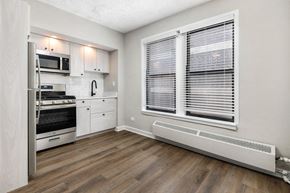 Chicago apartment for rent - Kitchen with hardwood floors, white cabinets and stainless steel appliances
