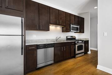 Chicago apartment for rent - a kitchen with wooden cabinets and stainless steel appliances