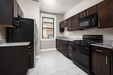 Chicago apartment for rent - a kitchen with black appliances and wooden cabinets
