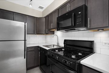 Chicago apartment for rent - a kitchen with black and white appliances and a stainless steel refrigerator