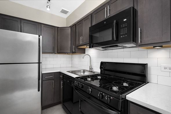 Chicago apartment for rent - a kitchen with black and white appliances and a stainless steel refrigerator