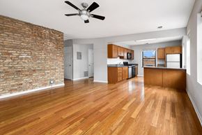 Chicago apartment for rent - an empty living room with a brick wall and wood floors