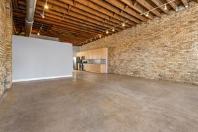 Chicago apartment for rent - a large room with a brick wall and concrete floors and a kitchen