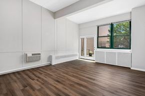 Chicago apartment for rent - an empty living room with wood floors and a window