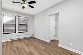 Chicago apartment for rent - Living room with hardwood floors, white walls and a ceiling fan