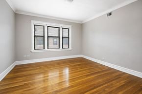 Chicago apartment for rent - an empty living room with wood floors and a window