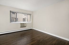 Chicago apartment for rent - an empty living room with wood floors and a window