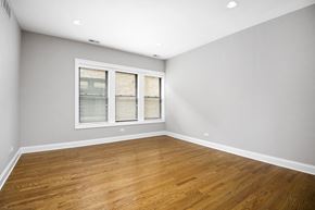 Chicago apartment for rent - an empty living room with wood floors and a window