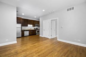 Chicago apartment for rent - a renovated living room and kitchen with white walls and wood floors