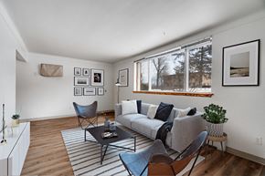 Roseville apartment for rent - A living room with a grey couch, a black coffee table, and a striped rug.