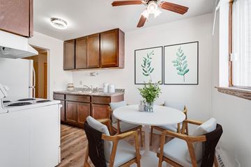 Roseville apartment for rent - A kitchen with a white table and chairs and a plant on it.