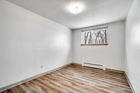 Roseville apartment for rent - A room with wooden flooring and a window with a view of trees.