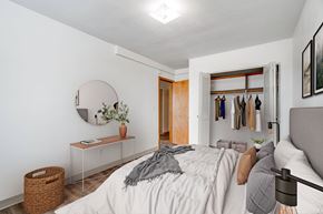 Roseville apartment for rent - A bedroom with a bed, a mirror, a dresser, and a basket.
