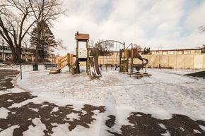 Roseville apartment for rent - A playground with a wooden swing set and a climbing frame.