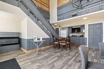 Wichita apartment for rent - A living room with a grey couch and a wooden floor.