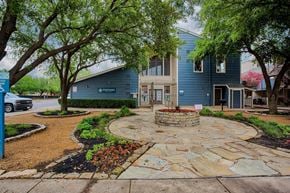 Dallas apartment for rent - A blue building with a stone walkway in front.