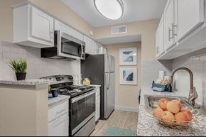 Winter Haven apartment for rent - A kitchen with a black refrigerator and white cabinets.