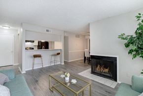 Wichita apartment for rent - A living room with a fireplace and a glass coffee table.