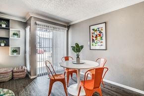 Dallas apartment for rent - A dining room with a white table and orange chairs.