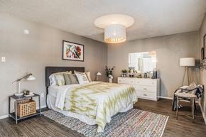 Dallas apartment for rent - A bedroom with a bed, nightstand, and chair.