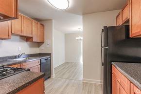 Silver Spring apartment for rent - A kitchen with wooden cabinets and a black refrigerator.