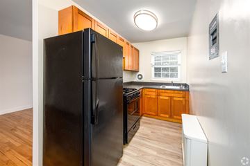 Silver Spring apartment for rent - A black refrigerator in a kitchen with wooden cabinets.