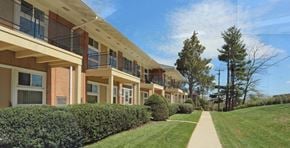 Rockville apartment for rent - A long building with balconies and a green lawn in front.
