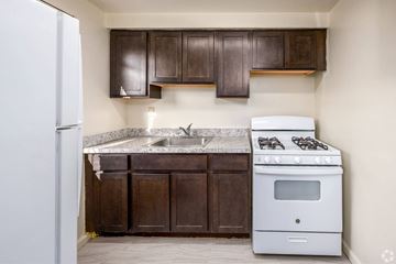 Silver Spring apartment for rent - A kitchen with a white stove and brown cabinets.
