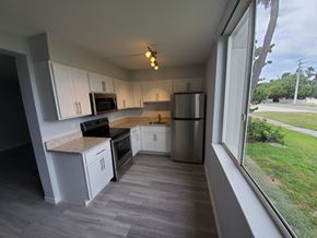 Cocoa Beach apartment for rent - A kitchen with white cabinets and a marble countertop.