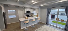 Cocoa Beach apartment for rent - A kitchen with a bar stool and a fridge.