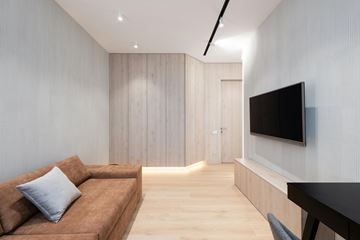 Austin apartment for rent - A modern living room with a brown couch and a flat screen TV mounted on the wall.