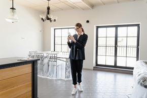 San Francisco apartment for rent - A woman in a black outfit is standing in a room with a wooden counter and a chandelier.