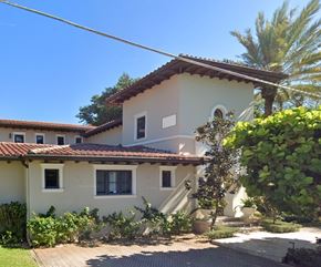 Davie apartment for rent - A house with a red tile roof and a white wall with a brown trim.