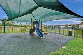 Miami apartment for rent - Gate enclosed, covered playground with a blue slide and a green canopy.
