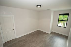 Davie apartment for rent - A room with a white door and a window with a view of trees.
