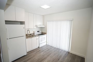 Miami apartment for rent - A kitchen with white cabinets and a refrigerator.