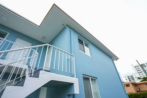 Miami apartment for rent - A blue house with a white balcony.
