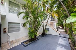 Miami apartment for rent - A white building with a tree in front of it.
