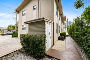 Miami apartment for rent - A modern house with a white door and a gravel pathway leading to it.