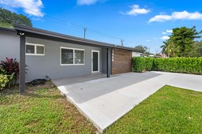 Pompano Beach apartment for rent - A grey house with a black door and a grey roof.