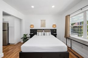 Miami apartment for rent - A bedroom with a large bed and a window with a view of the outside.