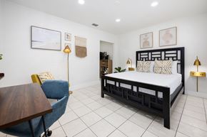 Miami apartment for rent - A bedroom with a bed, chair, and lamp.