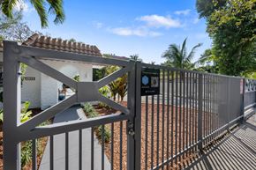 Miami apartment for rent - A metal gate with a sign that reads "IMAGE BOOKING" is in the foreground.