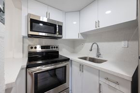 Miami apartment for rent - A modern kitchen with a stove, oven, and microwave.